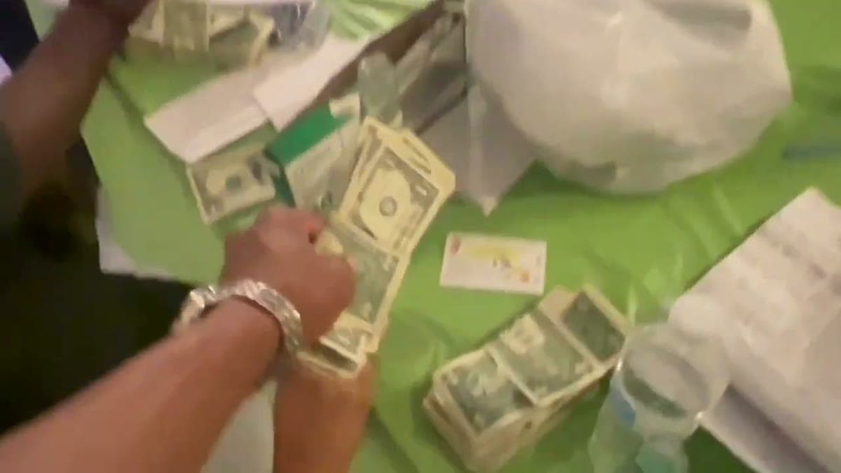 Banded stacks of donation cash being counted on a green tablecloth at the fundraiser
