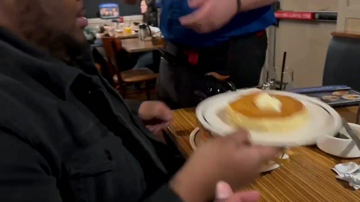 A late-night IHOP table with a plate of pancakes and diner coffee mugs