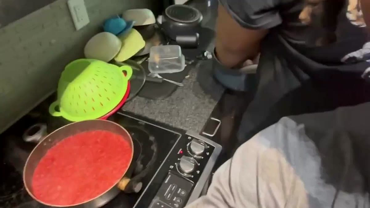 A pan of blended red pepper-and-tomato stew base on the stove in a friend's Dallas kitchen