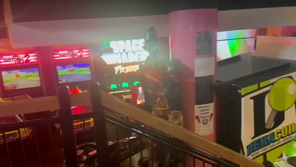 The neon-lit interior of an Ann Arbor arcade bar, rows of classic arcade cabinets